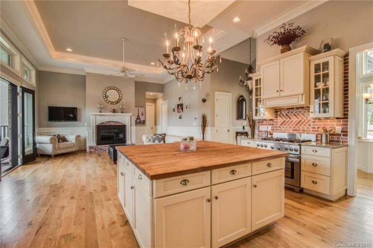 a beautiful kitchen featuring a butcher-block kitchen island and chandelier in a lake Norman custom home